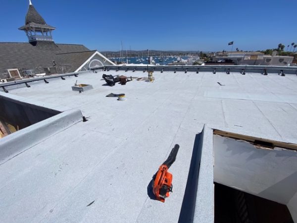 White reflective coating on a flat roof around skylight openings